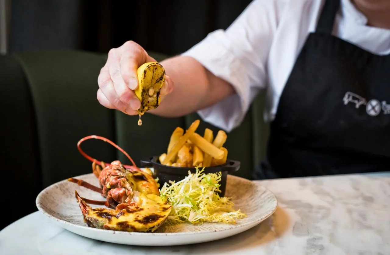 a person is holding a piece of food on a plate at Kimpton Blythswood Square Hotel & Spa by IHG in Glasgow