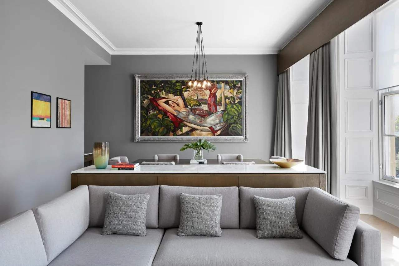 a living room with a couch and a painting on the wall at Kimpton Blythswood Square Hotel & Spa by IHG in Glasgow