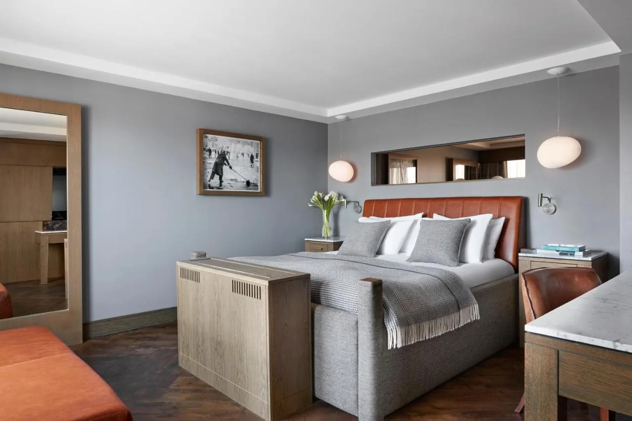 a bedroom with a large bed with a wooden headboard at Kimpton Blythswood Square Hotel & Spa by IHG in Glasgow