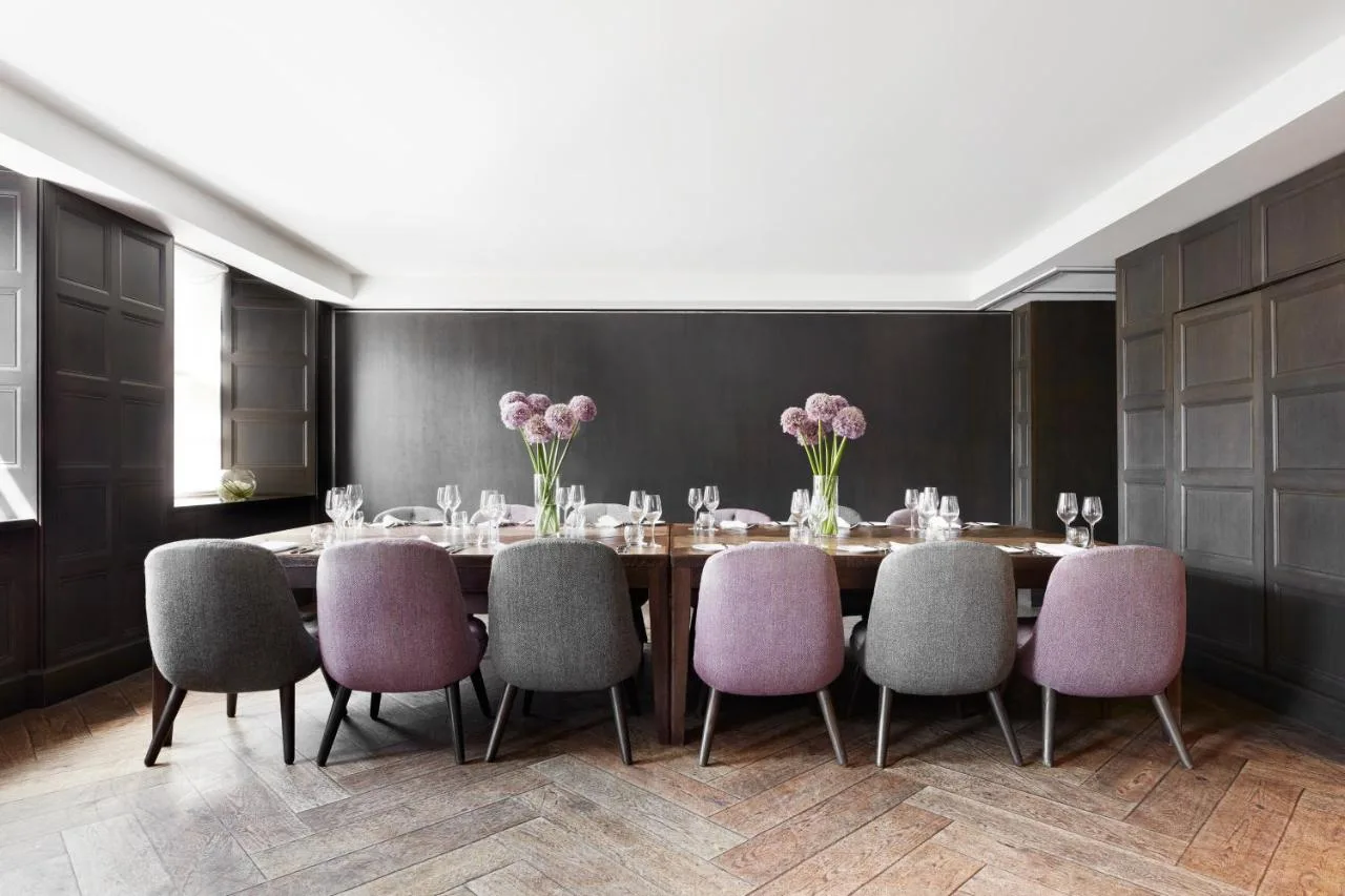a dining room with a table and purple chairs at Kimpton Blythswood Square Hotel & Spa by IHG in Glasgow