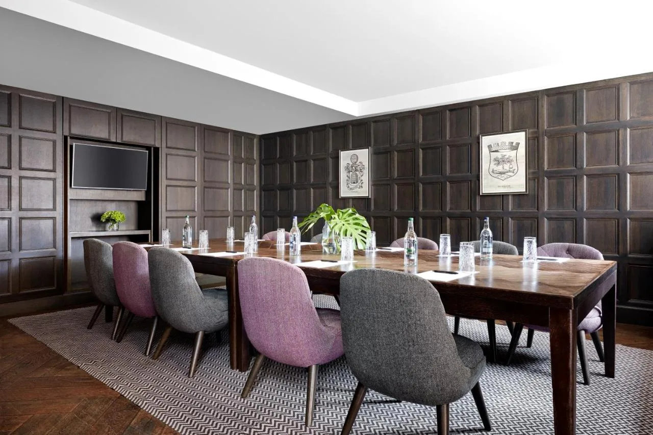 a dining room with a long table and purple chairs at Kimpton Blythswood Square Hotel & Spa by IHG in Glasgow